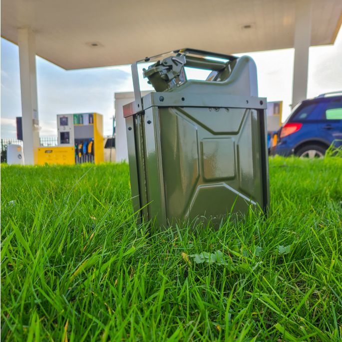 Groene jerrycanhouder groen met groene jerrycan in het gras voor tankstation