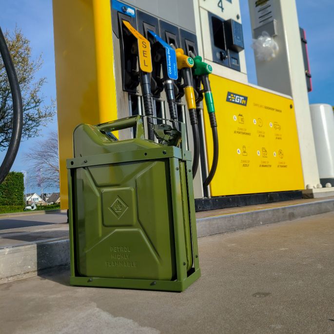 Groene jerrycanhouder groen met groene jerrycan naast benzinepomp
