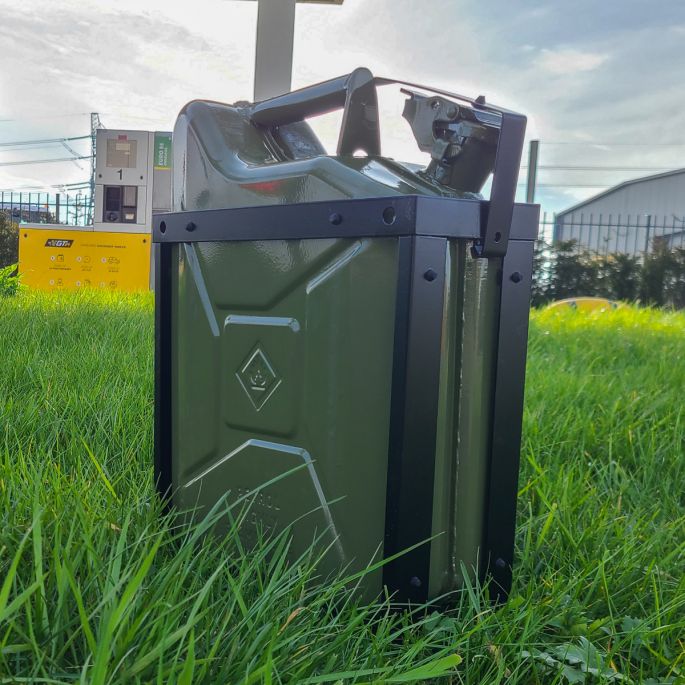 Zwarte jerrycanhouder met groene jerrycan in het gras voor tankstation