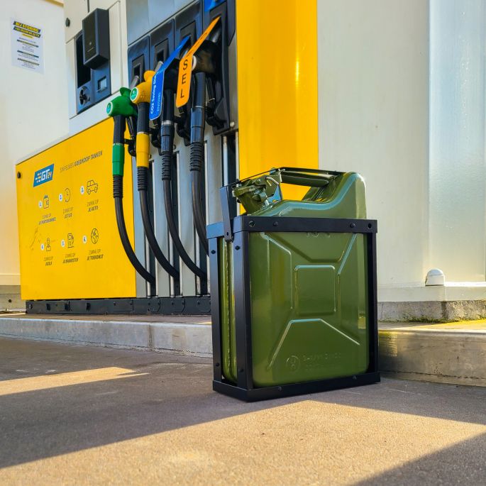 Zwarte jerrycanhouder groen met groene jerrycan naast benzinepomp