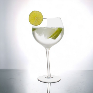 Scheef gin tonic glas gevuld met ijs en limoen op witte achtergrond